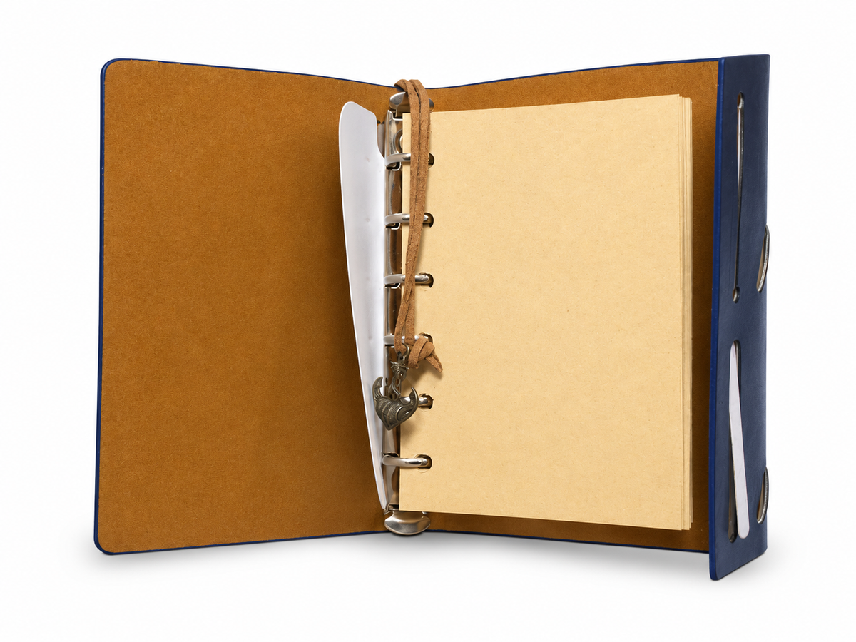 Carnet bleu Boussole ouvert avec six anneaux et pages vierges crème, sur fond blanc